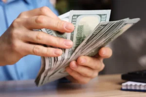 Dólar desacelera alta ante real com fluxo comercial positivo